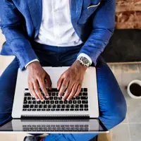 Top view of businessman sitting on longboard using laptop
