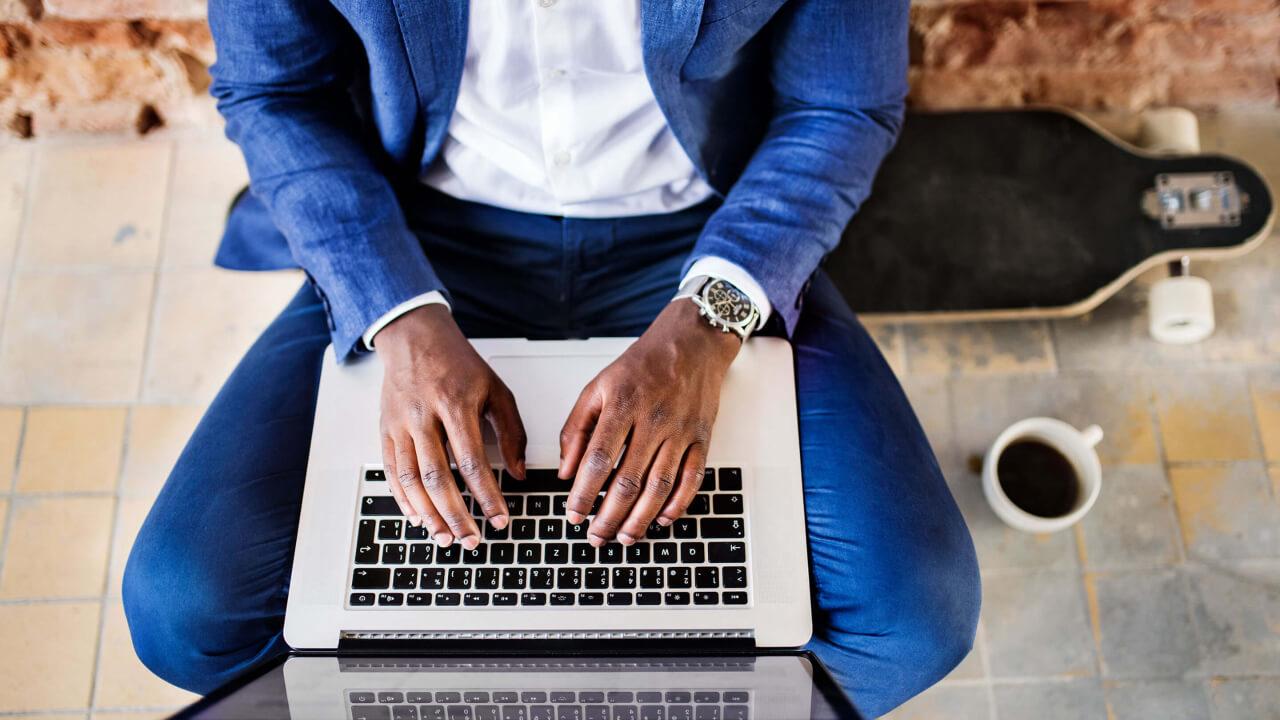 Top view of businessman sitting on longboard using laptop
